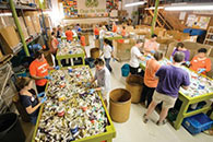 Group of people sorting through recycled plastics
